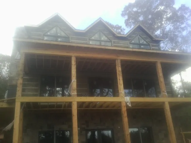 Dormers and porch framing on a large log home under construction — Roof Coating work by our crew in Hensonville