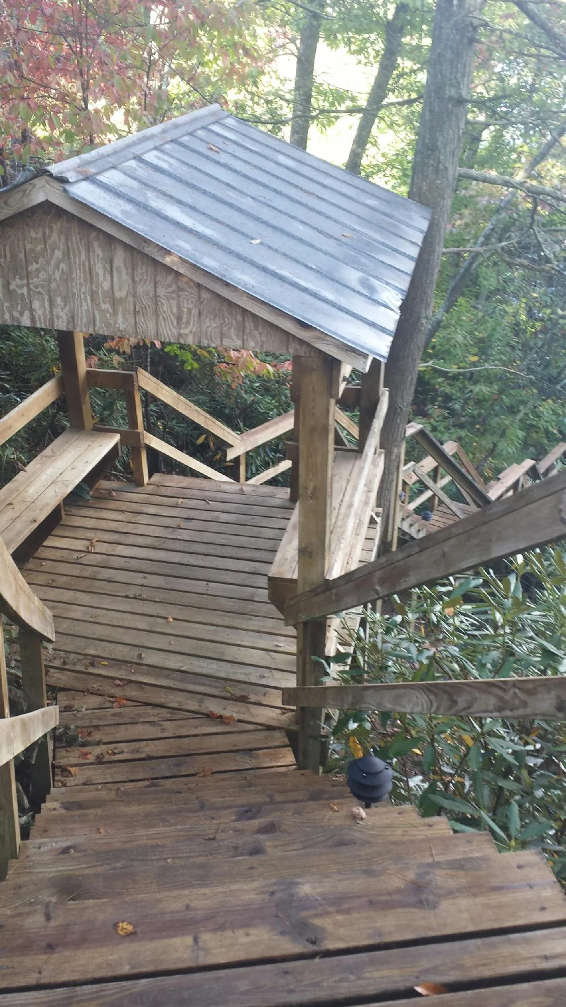 Metal roofed shelter over wooden steps on a wooded walkway — Skylight Repair & Installation work by our crew in Hensonville