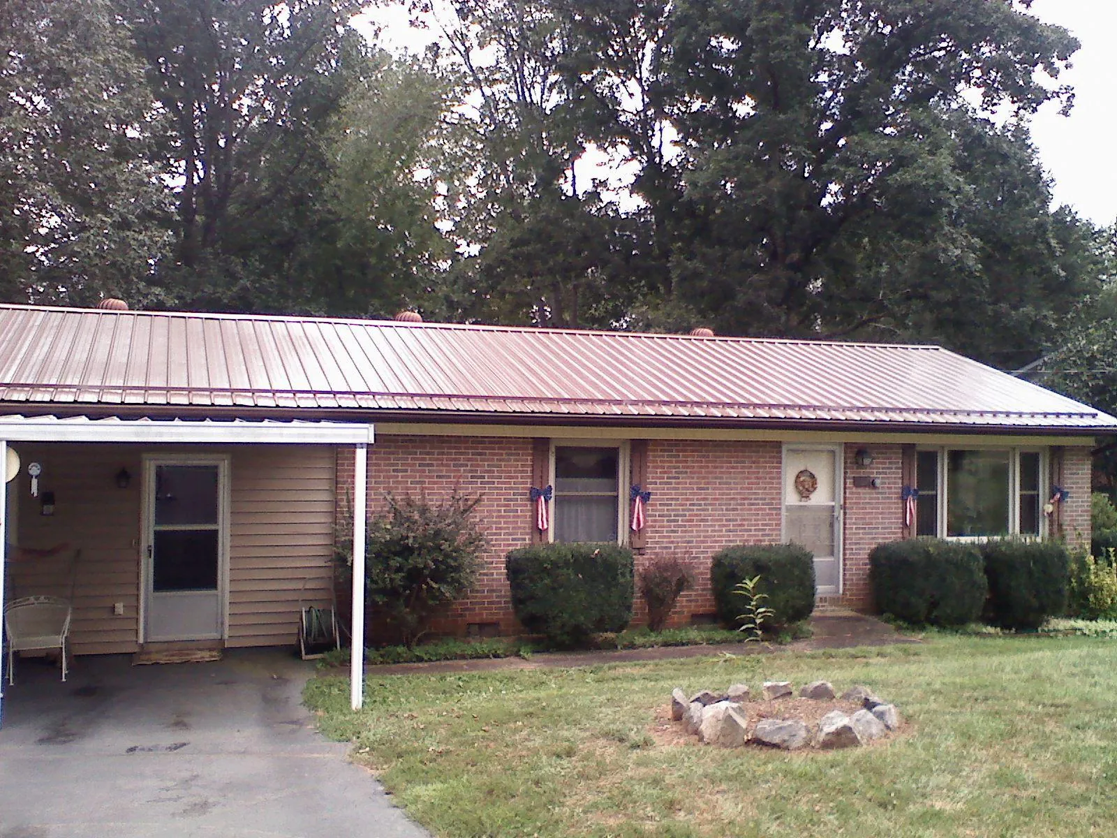 Bronze metal roof and carport on a brick ranch home in Hensonville